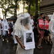 Marchers in New York wear veils and hold the pictures and names of people who died in the Buffalo shooting May 14.